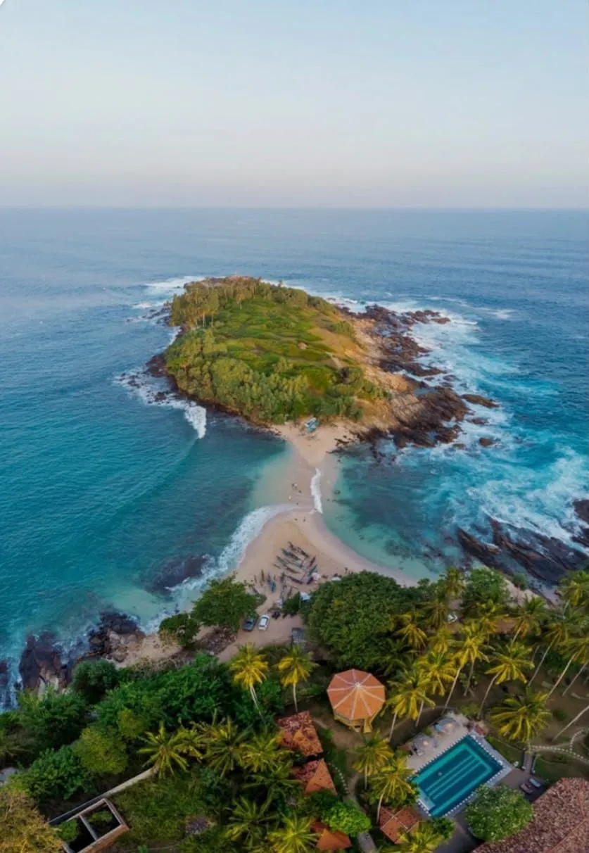 Blue Beach Island from above: the green, rocky island and the sandbar leading out to it from the shore