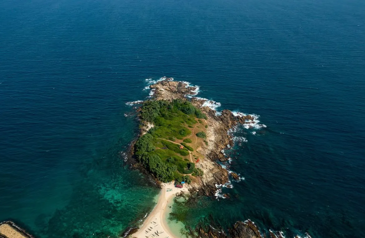 Blue Beach Island from straight above: the green, rocky island and the strip of sand leading out to it