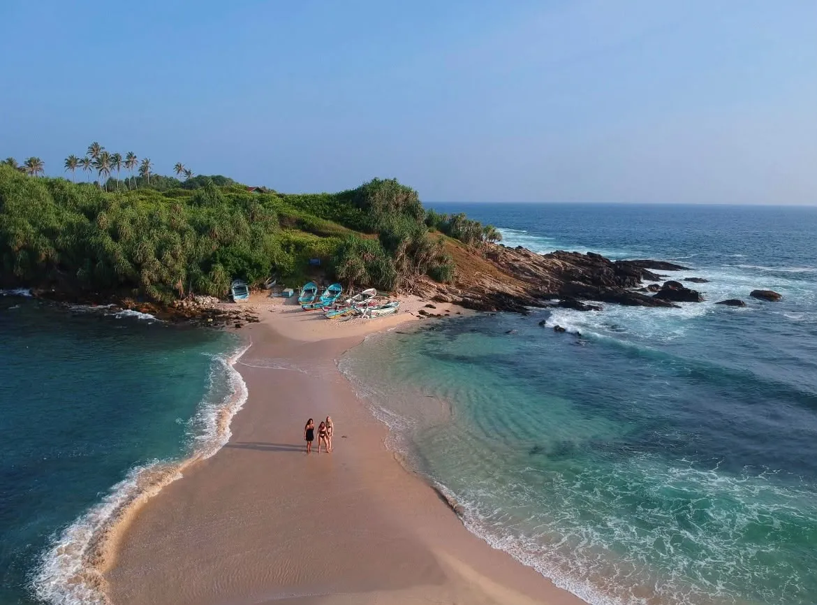 Drone view of Blue Beach Island in Nilwella: two people walking out on the sandbar, with the sea on both sides