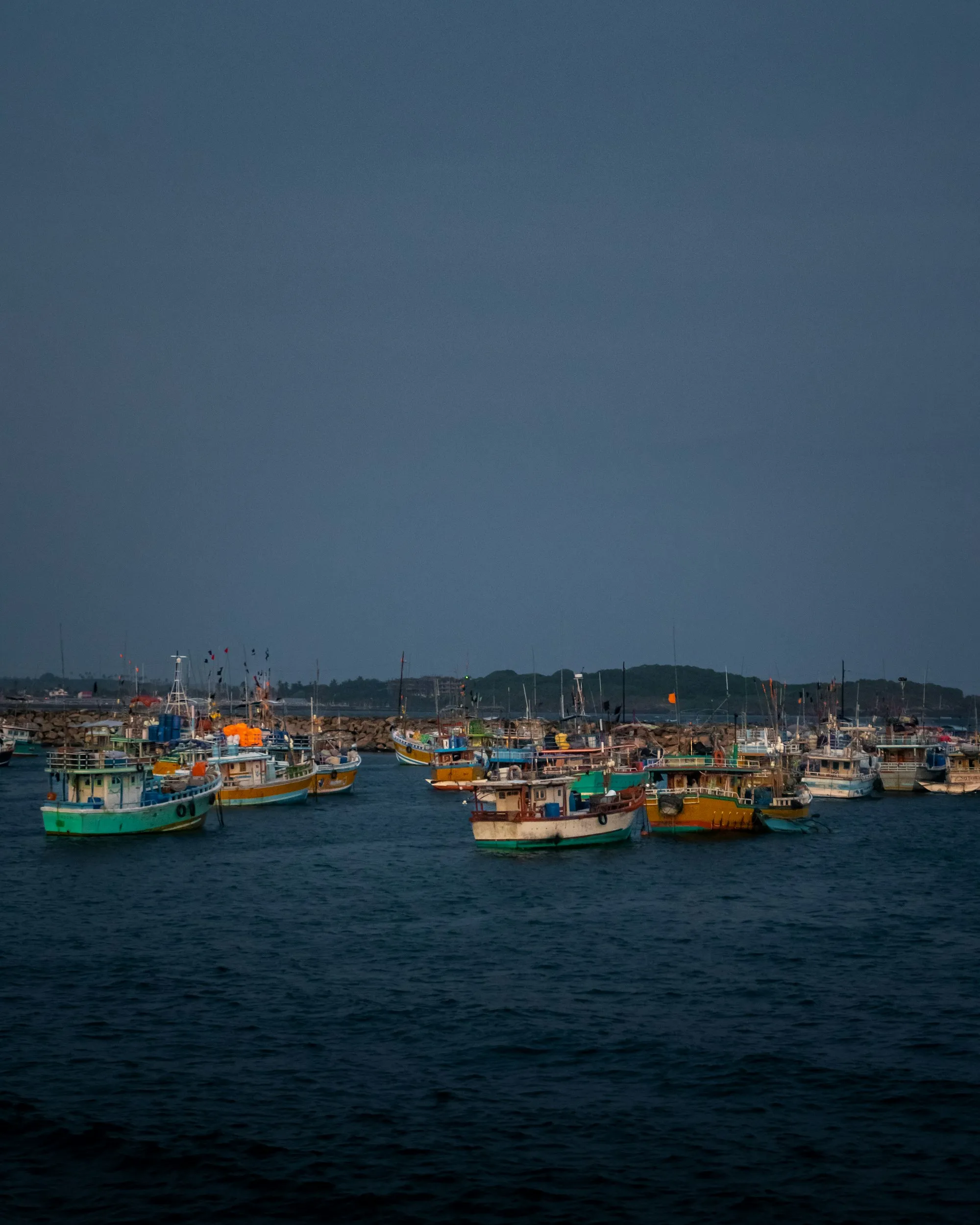 Fishing boats moored in Nilwella's fishery harbour under a stormy sky