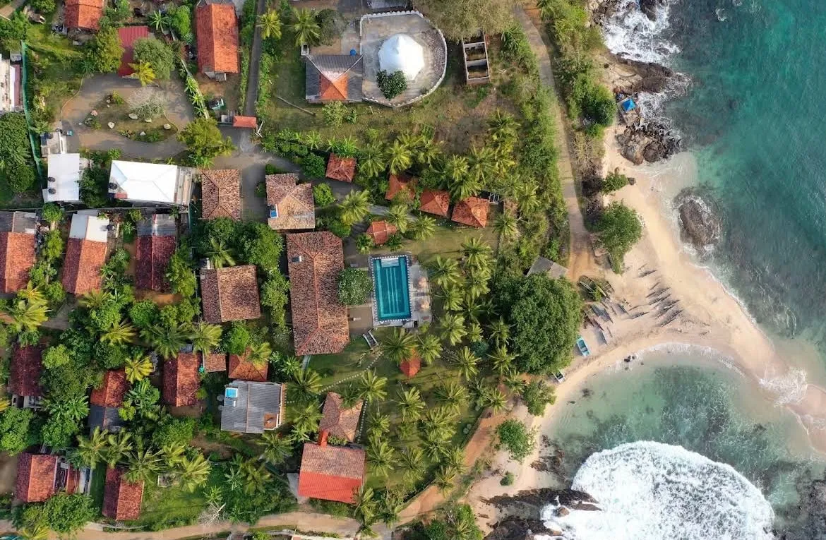Guesthouses and villas among the palms by the beach in Nilwella, seen from above